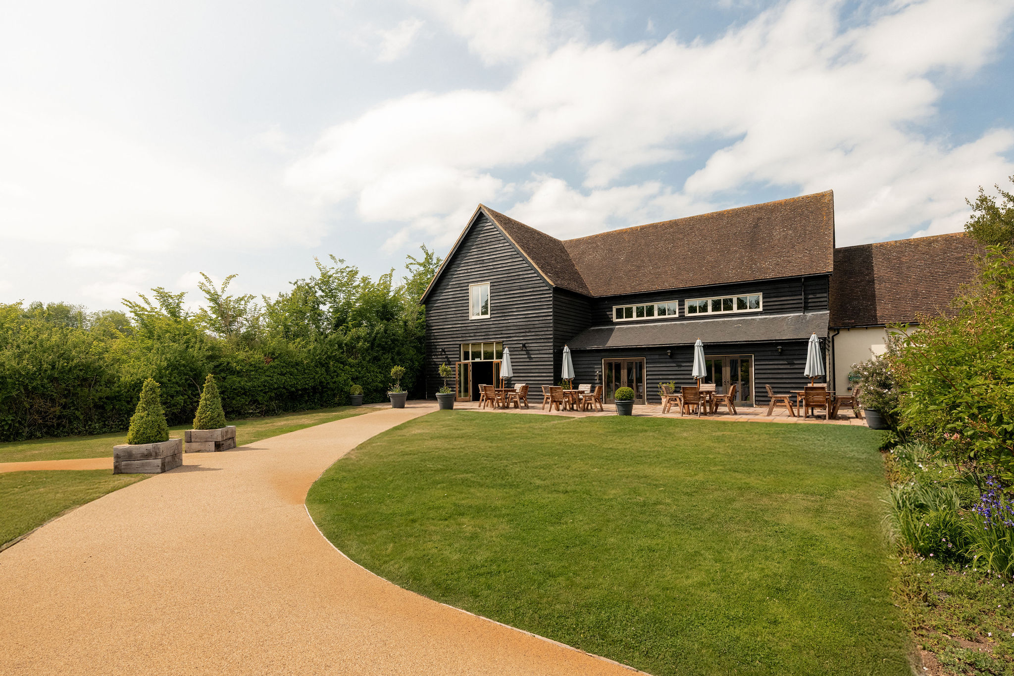 View of the wedding barn at The White Hart, Great Yeldham, Essex, showing its rustic timber-and-brick character.